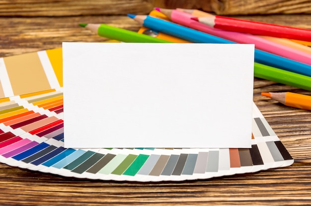 Пустая визитка с книгой образцов цвета и цветными карандашами