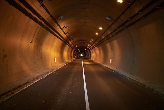 Фото Пустая автомобильная дорога в освещенном туннеле