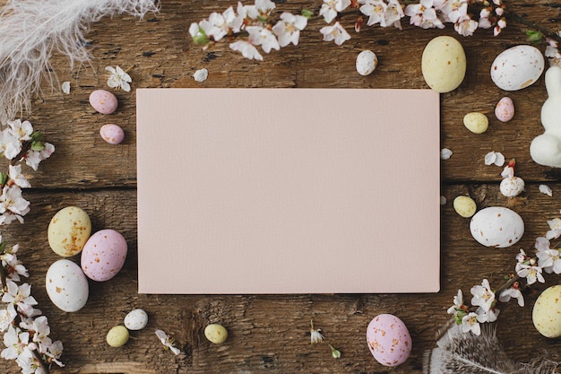 Empty card easter eggs feathers blooming branches on rustic wood Easter greeting card mock up