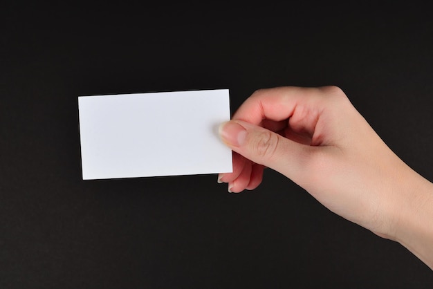 Empty card in woman hand on a black background