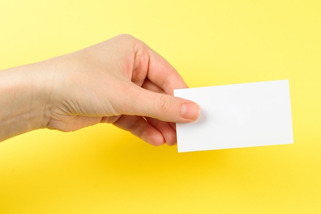 Empty card in woman hand  on a yellow background.