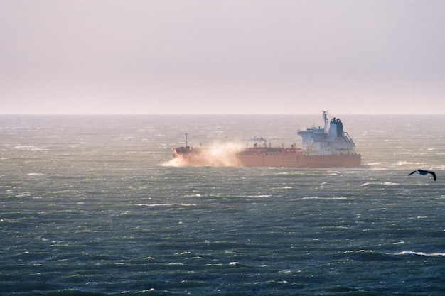 Empty cargo ship leaving San Francisco bay area and making its way through an agitated Pacific Ocean California