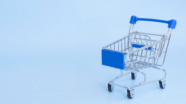 Empty cart from the supermarket on a light blue background