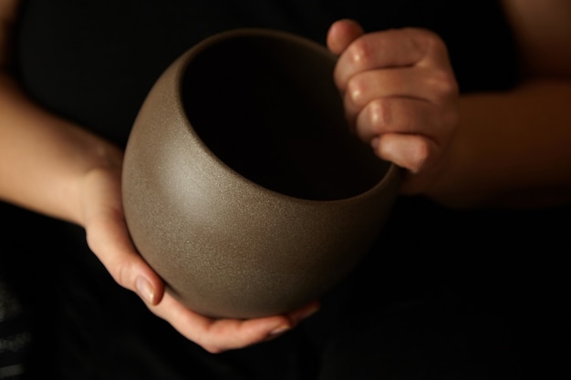 Empty ceramic flowerpot in hands of a woman