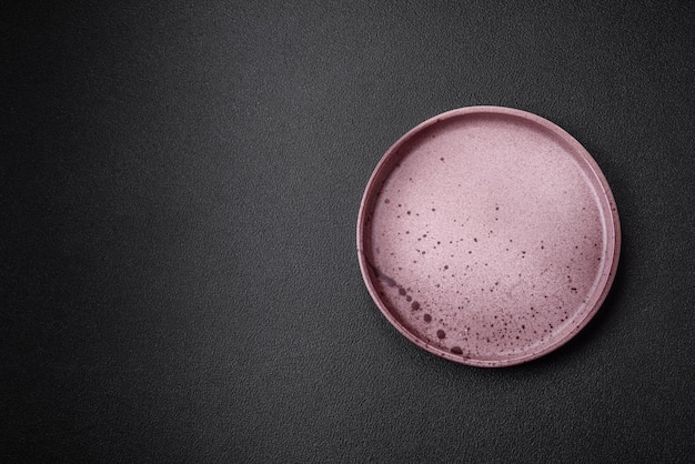Пустая керамическая тарелка на темном текстурированном фоне Подготовка кухонной утвари к семейному ужину