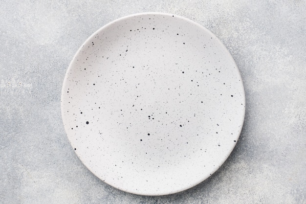 Empty ceramic plate on a light concrete