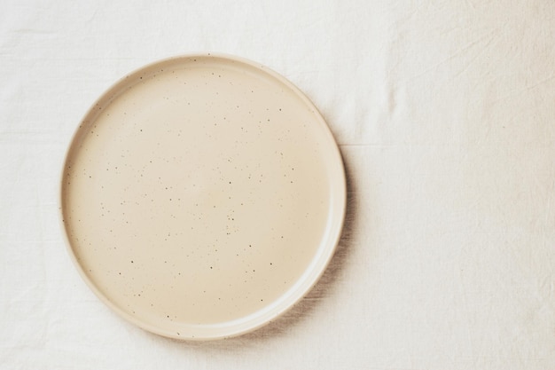 Photo empty ceramic shape plate for food on the table top view copy space template for your text