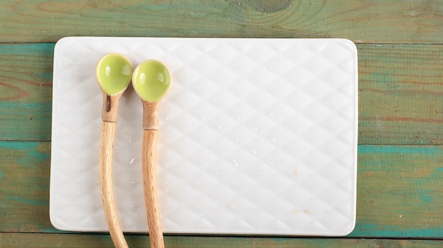 Empty Ceramic Spoons. Indonesia Handrafted Spoons with Natural Rustic Wooden Handle and Pastel Color. Copy Space for Text