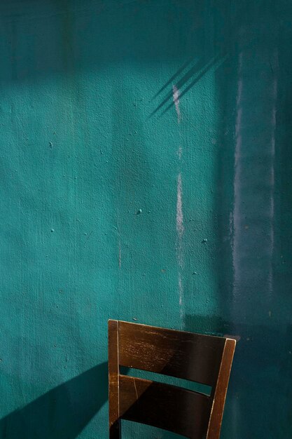 Empty chair against wall in old building