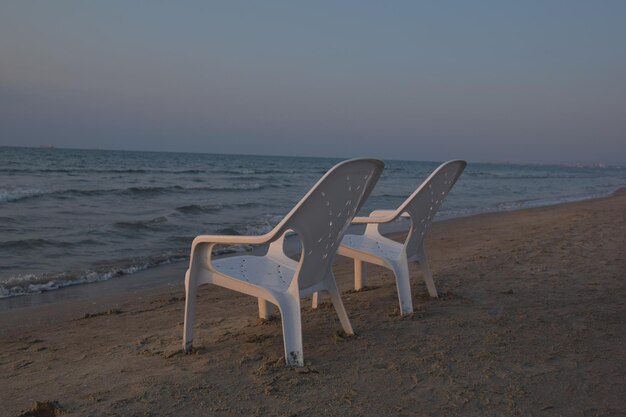晴れた空の背景にあるビーチの空の椅子