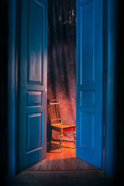 empty chair in light behind blue massive vintage doors indoor Old fashioned interior concept