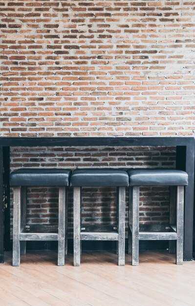 Photo empty chairs against brick wall