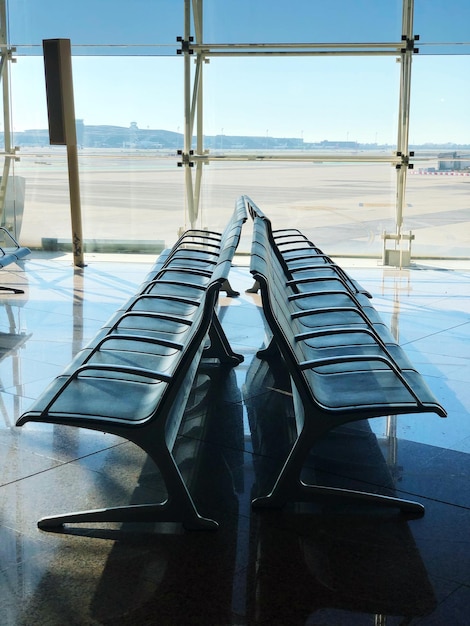 Empty chairs at airport against sky