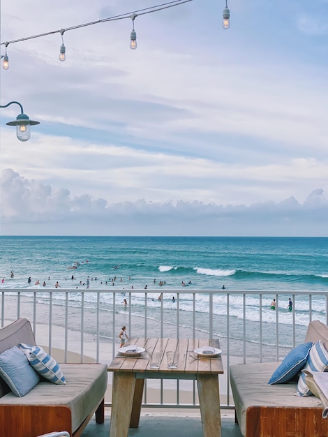 Фото Пустые стулья и стол на пляже на фоне неба