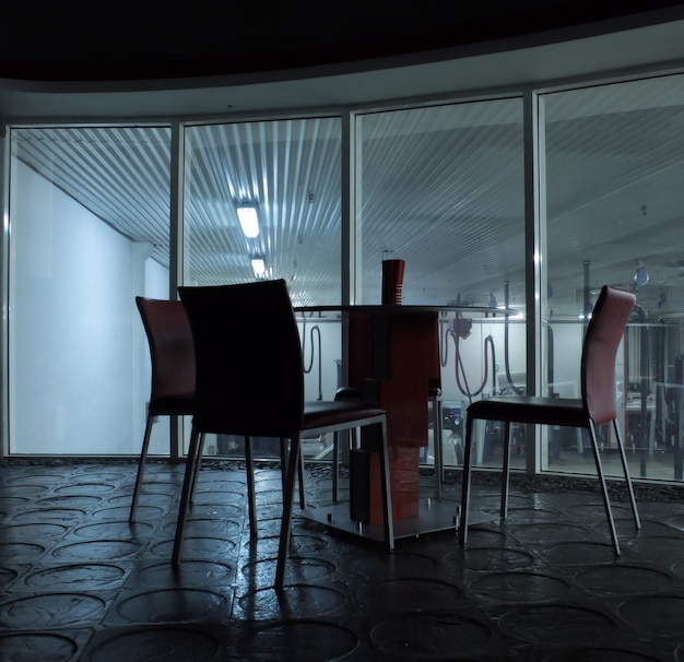 Empty chairs around table on second floor at car workshop