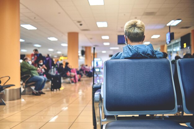 Photo empty chairs in the departure hall of the airport unrecognizable people blurred