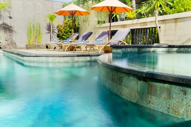 Photo empty chairs and parasols at poolside