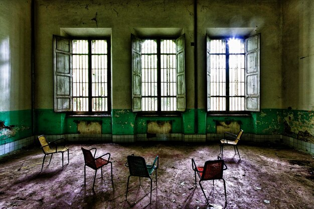 Пустые стулья и стол в заброшенном здании