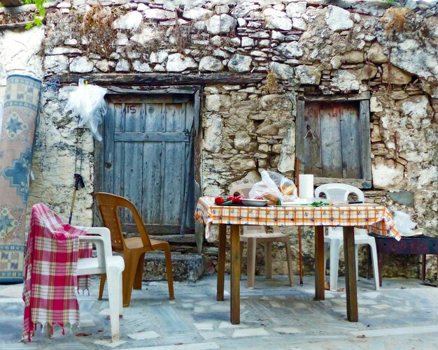 Foto sedie vuote e tavolo contro la vecchia casa