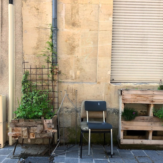 Empty chairs and table against wall of building