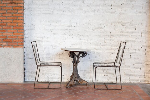 Empty chairs and table against wall