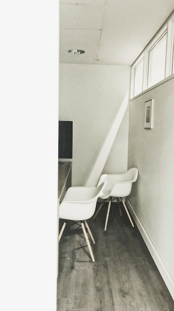 Photo empty chairs and table against white wall in building