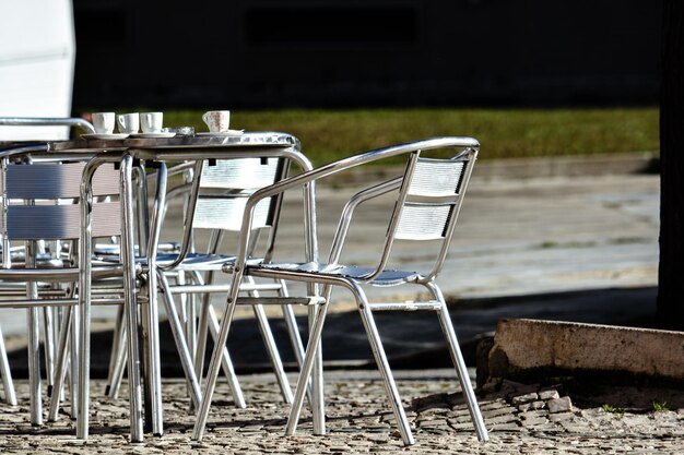 Empty chairs and table on field