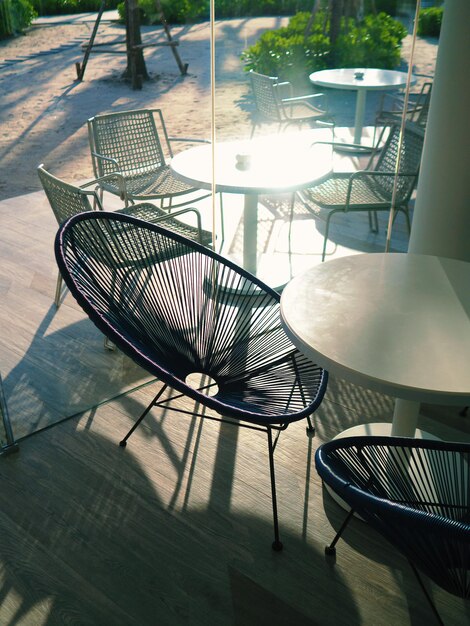 Empty chairs and table at sidewalk cafe