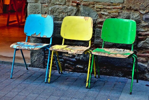 Photo empty chairs and tables against wall