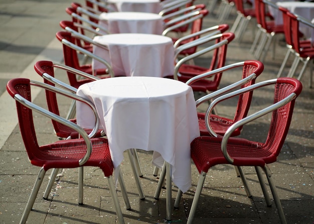 Foto sedie e tavoli vuoti disposti in un caffè sul marciapiede