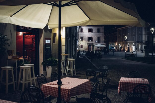 Foto sedie e tavoli vuoti in un caffè sul marciapiede in città