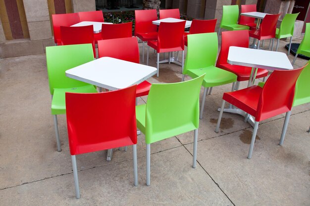 Empty chairs and tables at sidewalk cafe