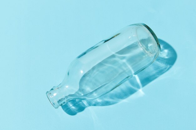 Empty class bottle on blue background. Zero waste low-waste living recycle concept