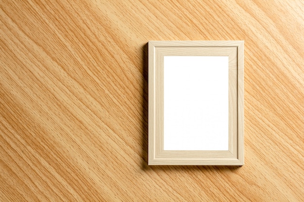 Empty classic wooden photo frame on wooden desk.