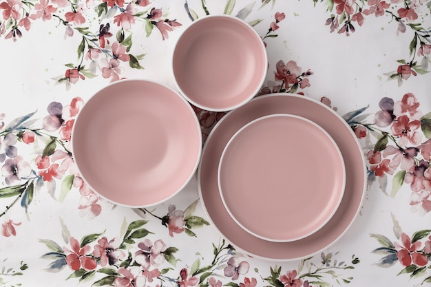 흰색 식탁보에 꽃무늬 테이블 상단 전망이 있는 빈 깨끗한 접시 플랫 레이 미니멀리즘 디자인 핑크 세라믹 그릇 식사를 서빙하고 먹기 위한 트렌디한 식기 세트 베이지색 요리