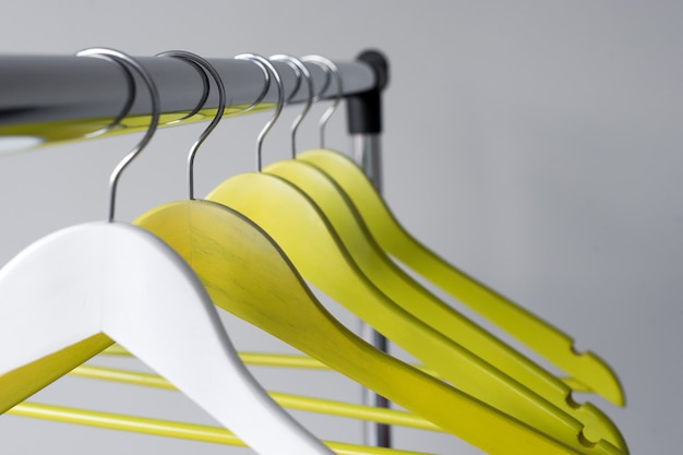 Empty clothes hangers on metal rail on grey