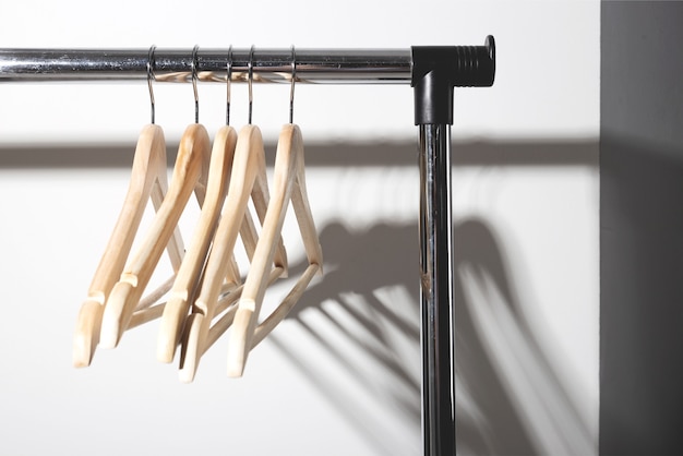 Empty clothes hangers on plain conscious consumption slow fashion concept minimalist