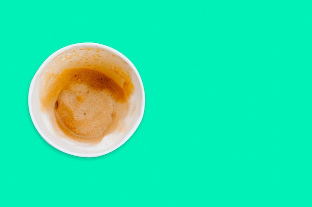 緑の背景に分離された飲み物とコーヒーの汚れの後に空のコーヒーカップ紙。上面図。最小限