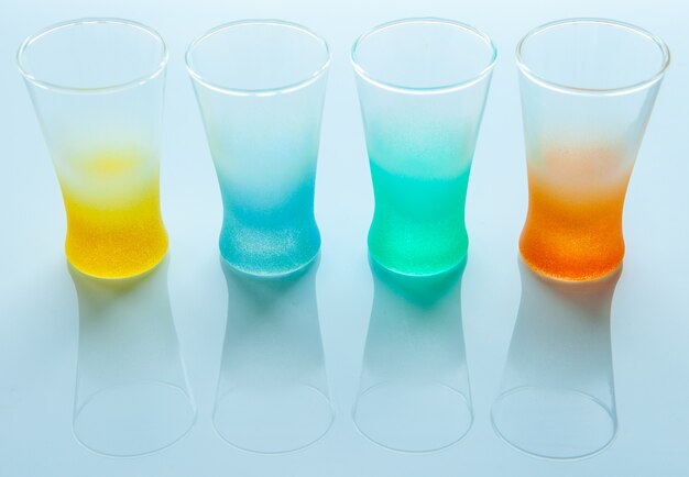 Empty colored glasses for different drinks on a white background