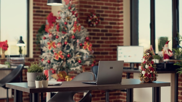 Photo empty company office decorated with festive ornaments to celebrate winter holiday season with christmas tree and lights. workplace with seasonal decorations for xmas event tradition.