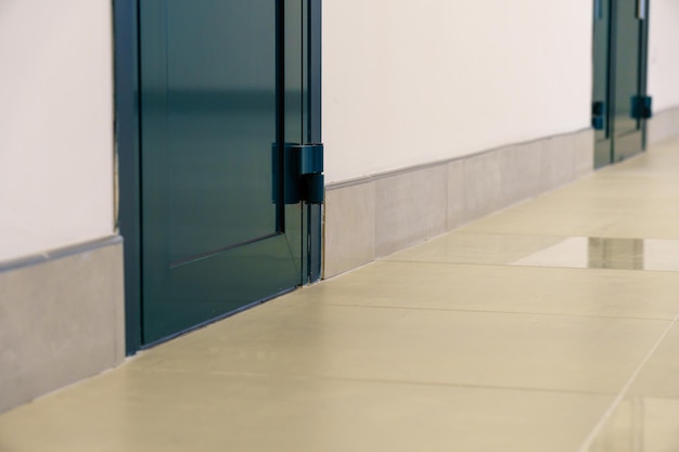 An empty corridor in an office building Closed doors to the office and lobby A spacious bright hall in the business center Entrance and exit from the room