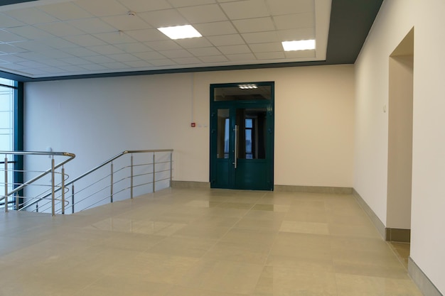 An empty corridor in an office building Closed doors to the office and lobby A spacious bright hall in the business center Entrance and exit from the room