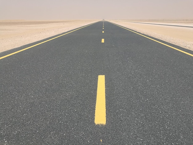 Empty country road on landscape against sky
