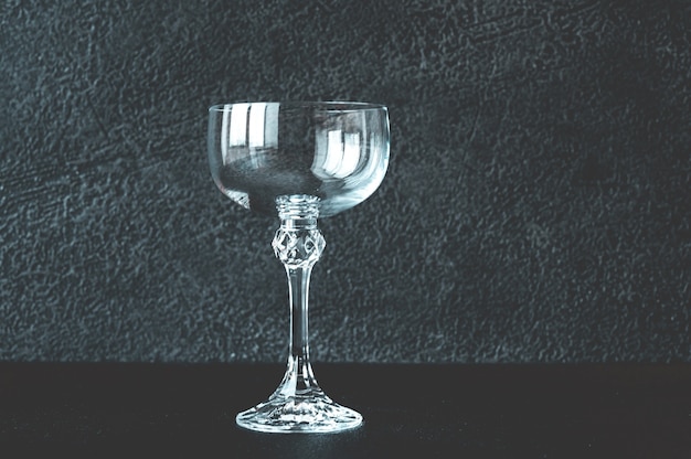 Empty coupe glass on black table close-up