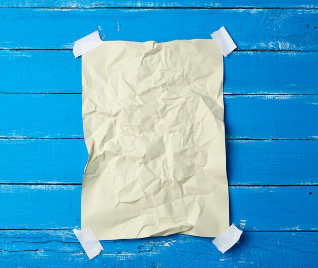 Empty crumpled sheet of paper glued with adhesive tape in the corners