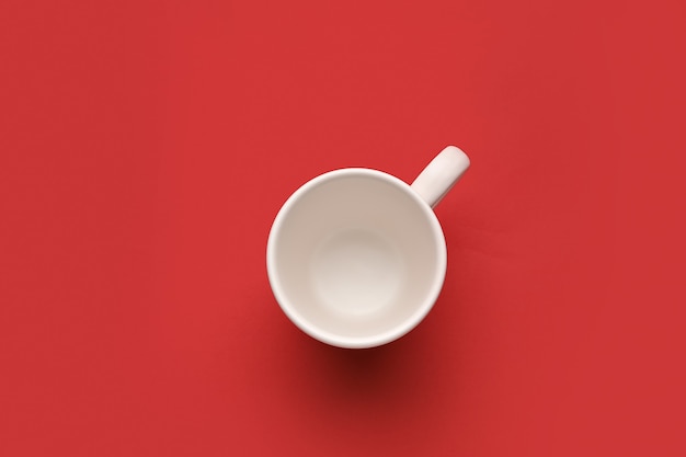 Empty cup on color surface