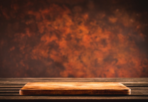 Empty cutting board on wooden table with brown background wall