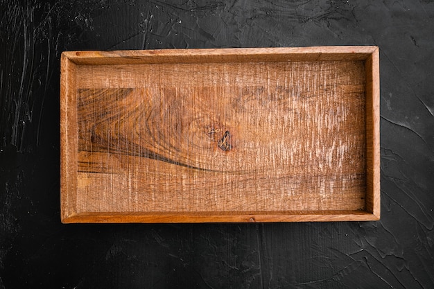 Empty dark wooden box set with copy space for text or food, top view flat lay, on black dark stone table background