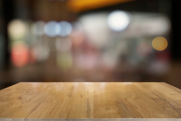 Empty dark wooden table in front of abstract blurred background of cafe and coffee shop interior. can be used for display or montage your products.