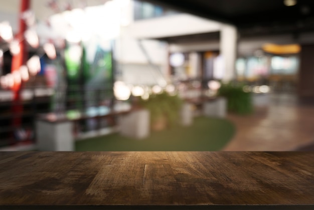 Empty dark wooden table in front of abstract blurred background of cafe and coffee shop interior. can be used for display or montage your products.